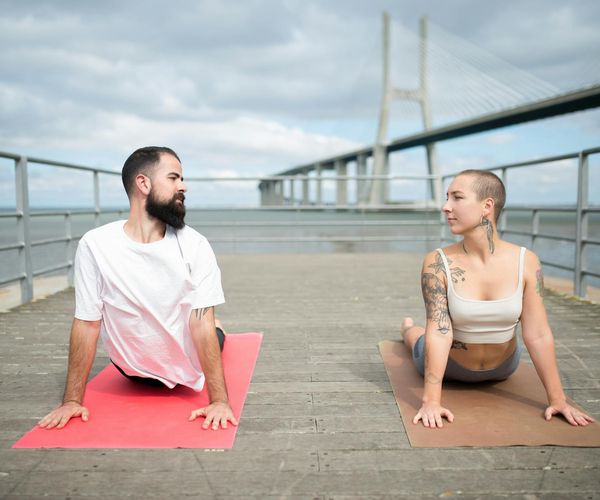 Man stretching outdoors at sunrise, looking serene and focused.